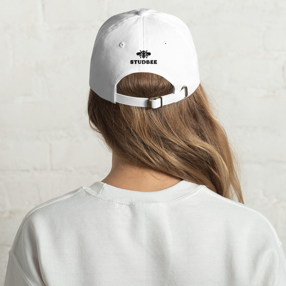 female model wearing white lego brick dad hat, view from the back, there is a studbee embroidered logo
